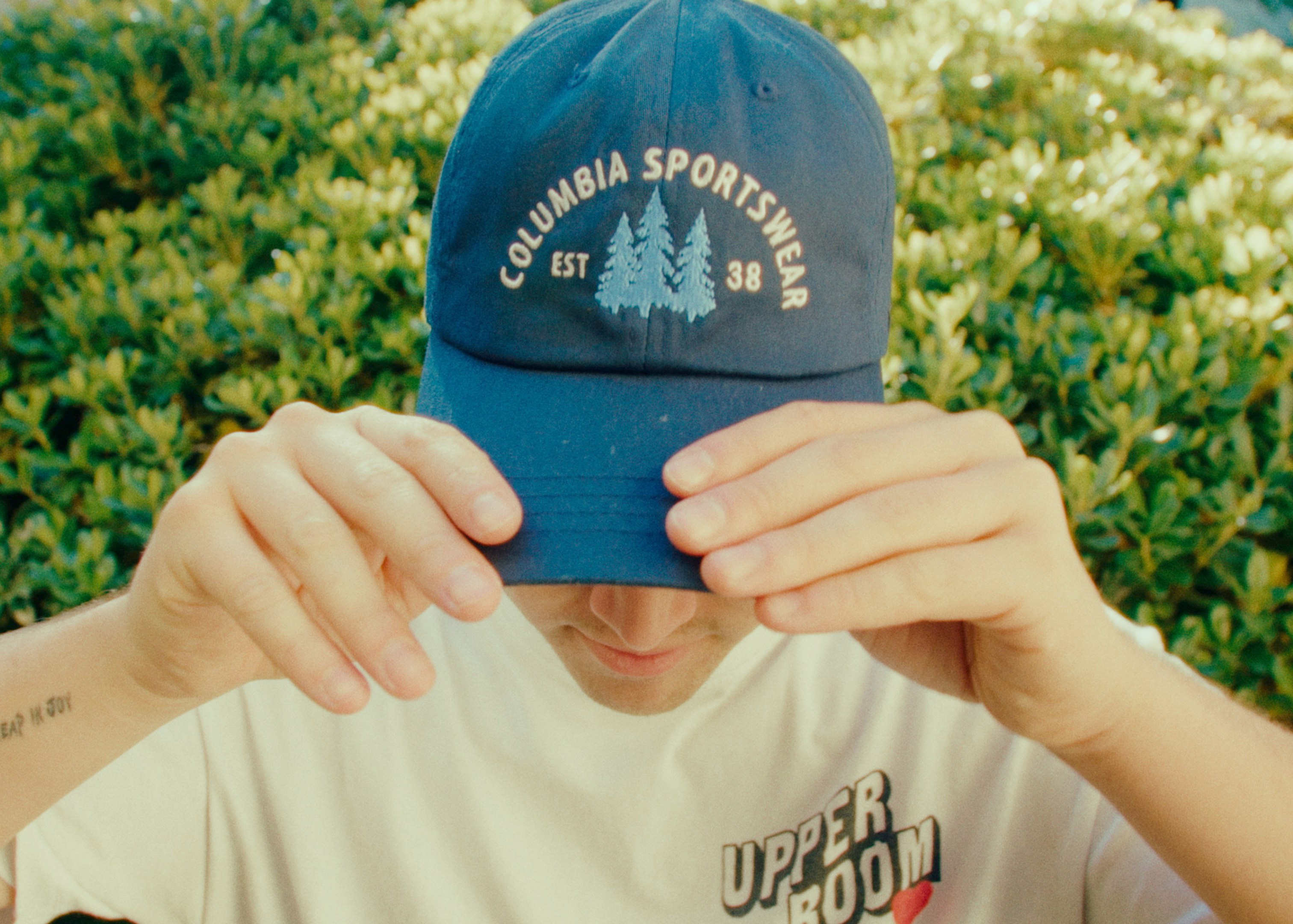 man in white and blue crew neck t-shirt wearing blue and white fitted cap